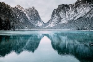 body of water and snow-covered mountains during daytime